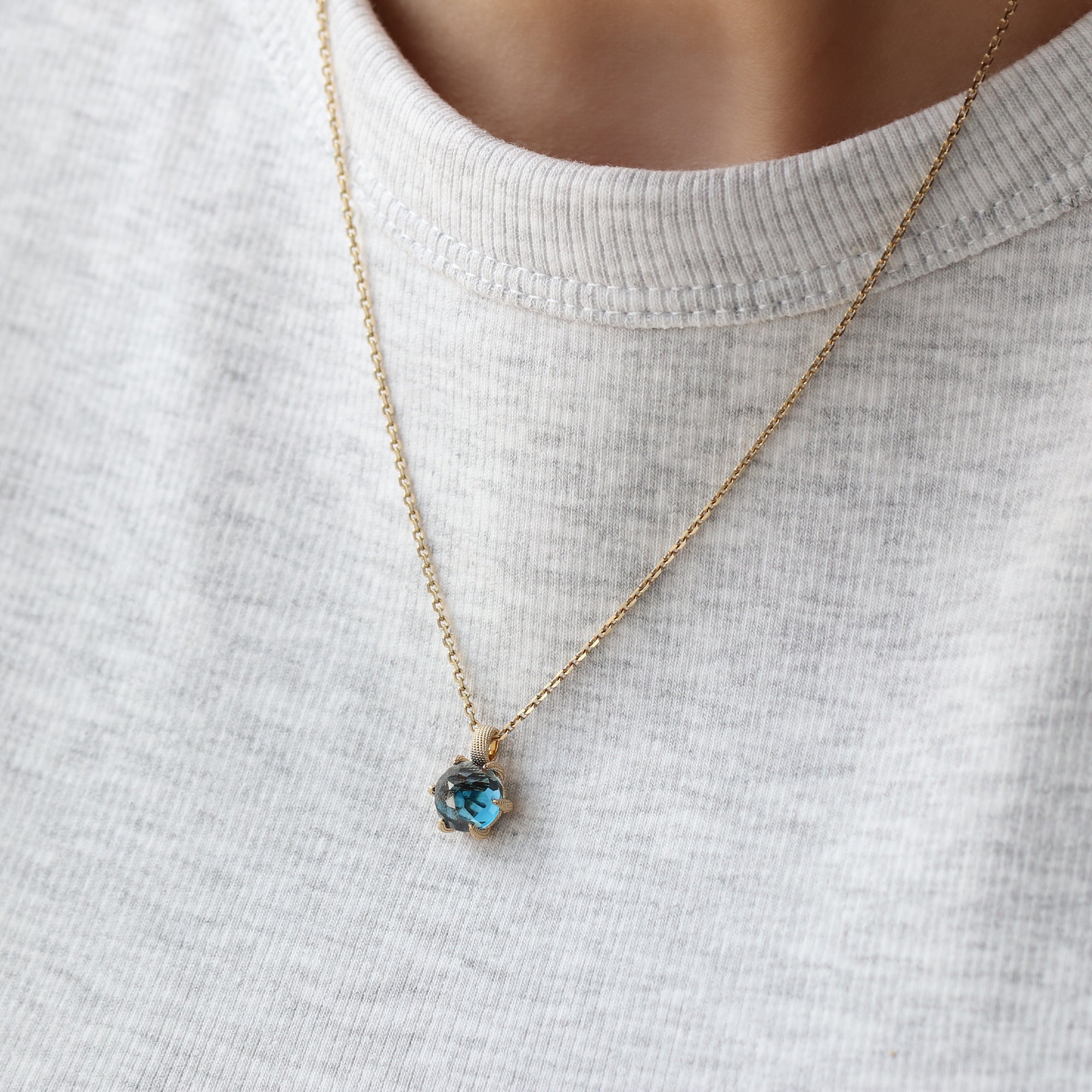 14-karaats gouden ketting met London Blue Topaas hanger in florentine finish, luxe sieraad dat creativiteit en kracht symboliseert, gedragen om hals, narrae