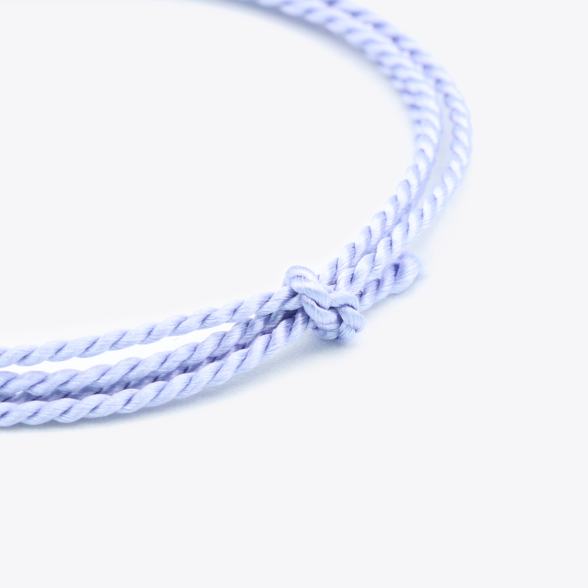 Close-up van lila, lichtpaars natuursatijn koord voor het maken van een armband of ketting