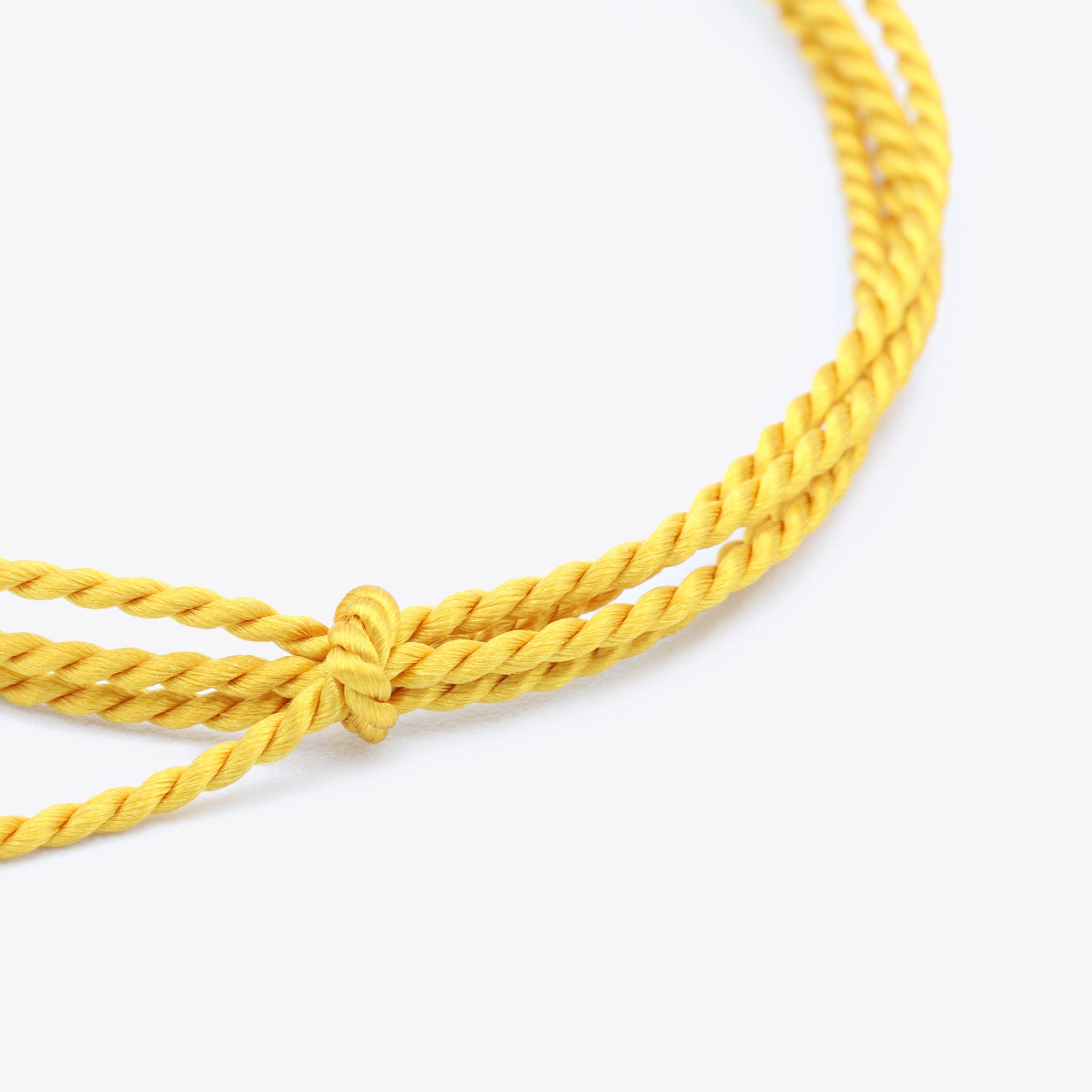 Close-up van okergeel natuursatijn koord voor het maken van een armband of ketting