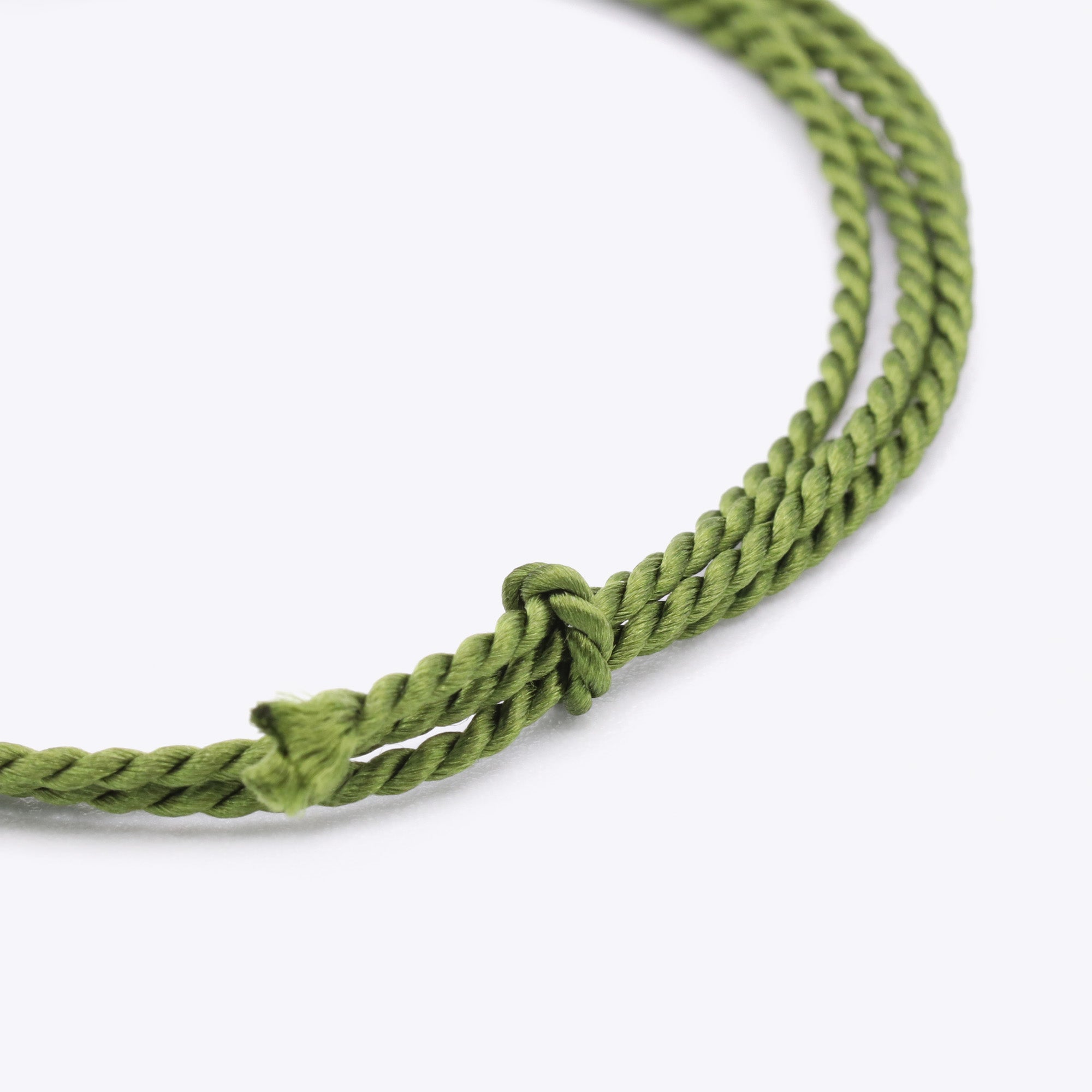 Close-up van olijfgroen, donkergroen natuursatijn koord voor het maken van een armband of ketting