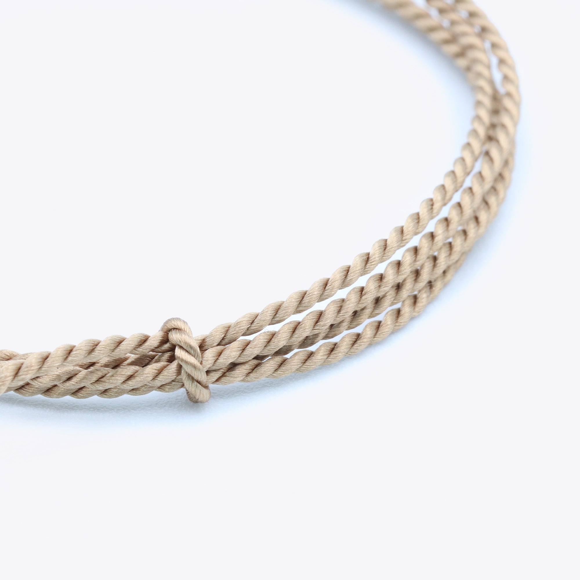 Close-up van taupe natuursatijn koord voor het maken van een armband of ketting