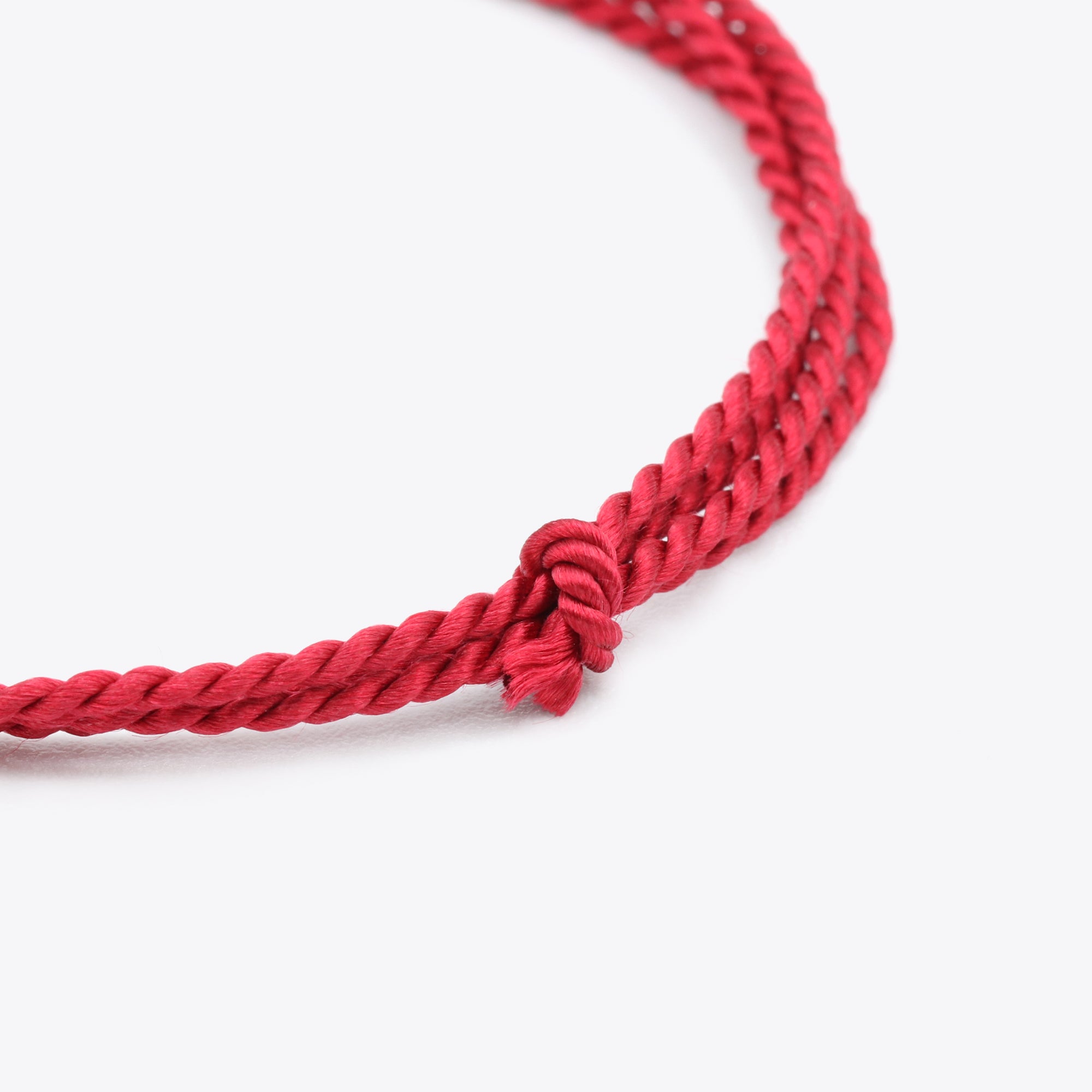 Close-up van bordeaux, donkerrood natuursatijn koord voor het maken van een armband of ketting