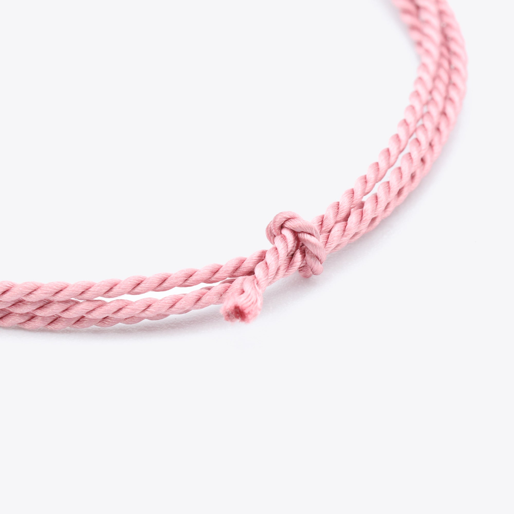 Close-up van donkerroze natuursatijn koord voor het maken van een armband of ketting