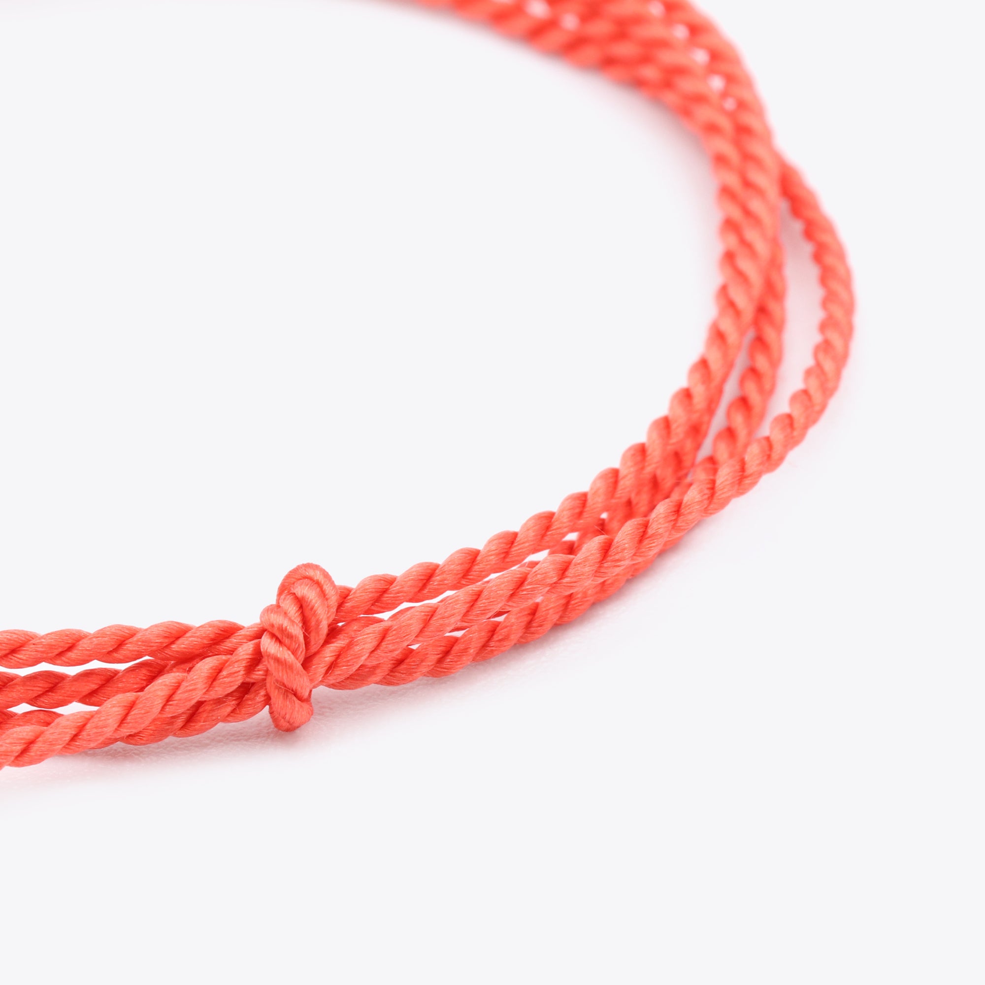 Close-up van koraal, oranje natuursatijn koord voor het maken van een armband of ketting